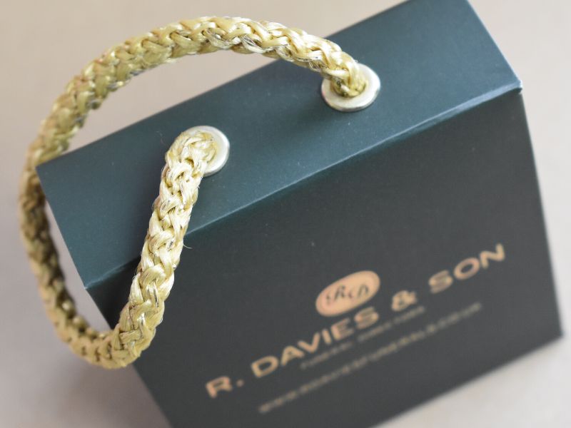 Luxury bespoke miniature paper bag with gold foil blocking and gold rope handle as well as a velcro closure to the flap