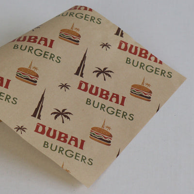 Kraft paper with 'Dubai Burgers' branding and graphics on a white background